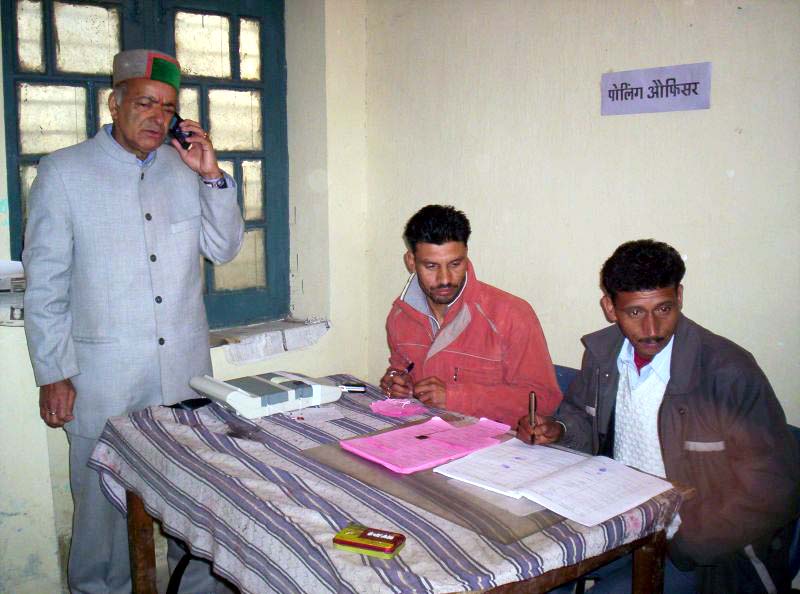 thakur-singh-bharmauri-of-congress-casting-his-vote-while-tlaking-on-phone.jpg