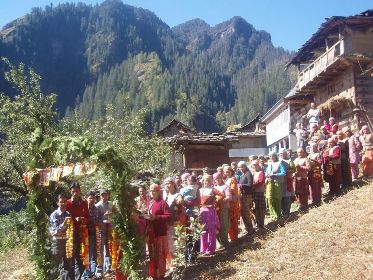 Voters waiting to recieve an election candidate in a Rohru village