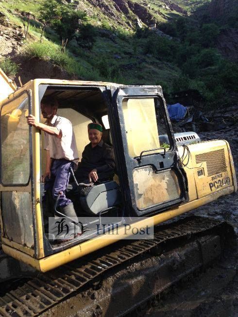 June File Photo of a stranded Virbhadra Singh, the chief minister riding a excavator to get to a nearby helipad in Sangla, Kinnaur