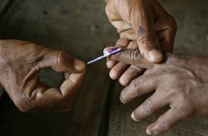 Polling officer applies ink on the finger on voters finger